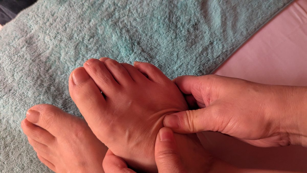Massage des pieds : pression du pouce sous la voûte plantaire